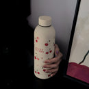 Gourde Cery isotherme 500 ml beige posée sur un bureau moderne