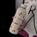 Gourde Cery 500 ml beige avec motifs cerise et cœur dans un style de vie quotidien.