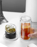 Gourde en verre avec infuseur TEVA 390 ml — gourde ouverte avec compartiment à thé posé à côté.