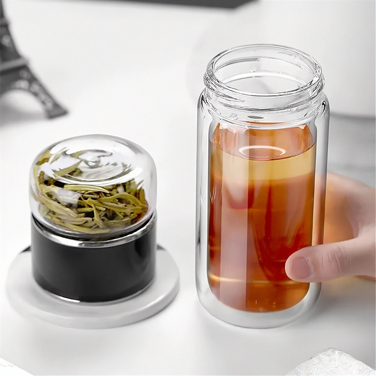 Gourde en verre avec infuseur TEVA 390 ml — verre ouvert et infuseur noir posé à côté.