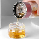 Gourde en verre avec infuseur TEVA 390 ml — versement du thé à travers le filtre métallique.
