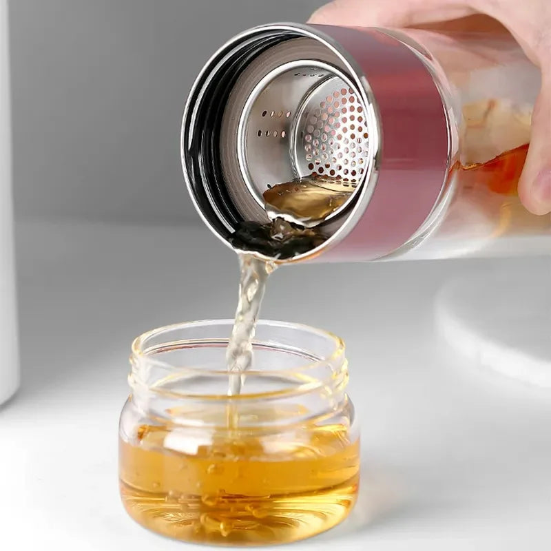 Gourde en verre avec infuseur TEVA 390 ml — versement du thé à travers le filtre métallique.