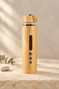 Gourde en verre et bambou MAE 500 ml — vue de face sur un socle en pierre.