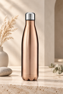 Gourde inox isotherme SILO — finition dorée rosée dans un décor intérieur.