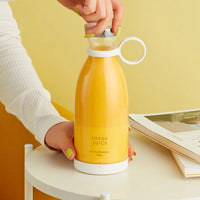 Mini mixeur RENA contenant une boisson jaune, tenu par le bouchon