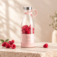 Mini mixeur RENA rose rempli de fraises, avec boisson et fruits à côté