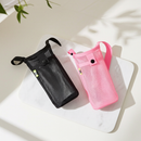 Porte-gourde bandoulière en maille SENA — modèles noir et rose sur une table.