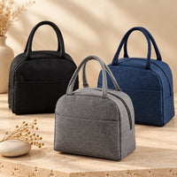 Sac repas isotherme VEYO — modèles noir, gris et bleu marine dans un décor intérieur.